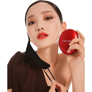 Skin TOGO model holding a red TIRTIR Mask Fit Red Cushion compact with a black face mask, showcasing flawless skin.