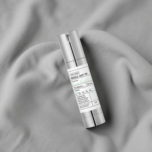Skin TOGO VT Cosmetics Reedle Shot 100 essence bottle on soft grey fabric for skin texture improvement