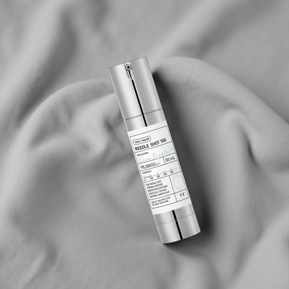 Skin TOGO VT Cosmetics Reedle Shot 100 essence bottle on soft grey fabric for skin texture improvement