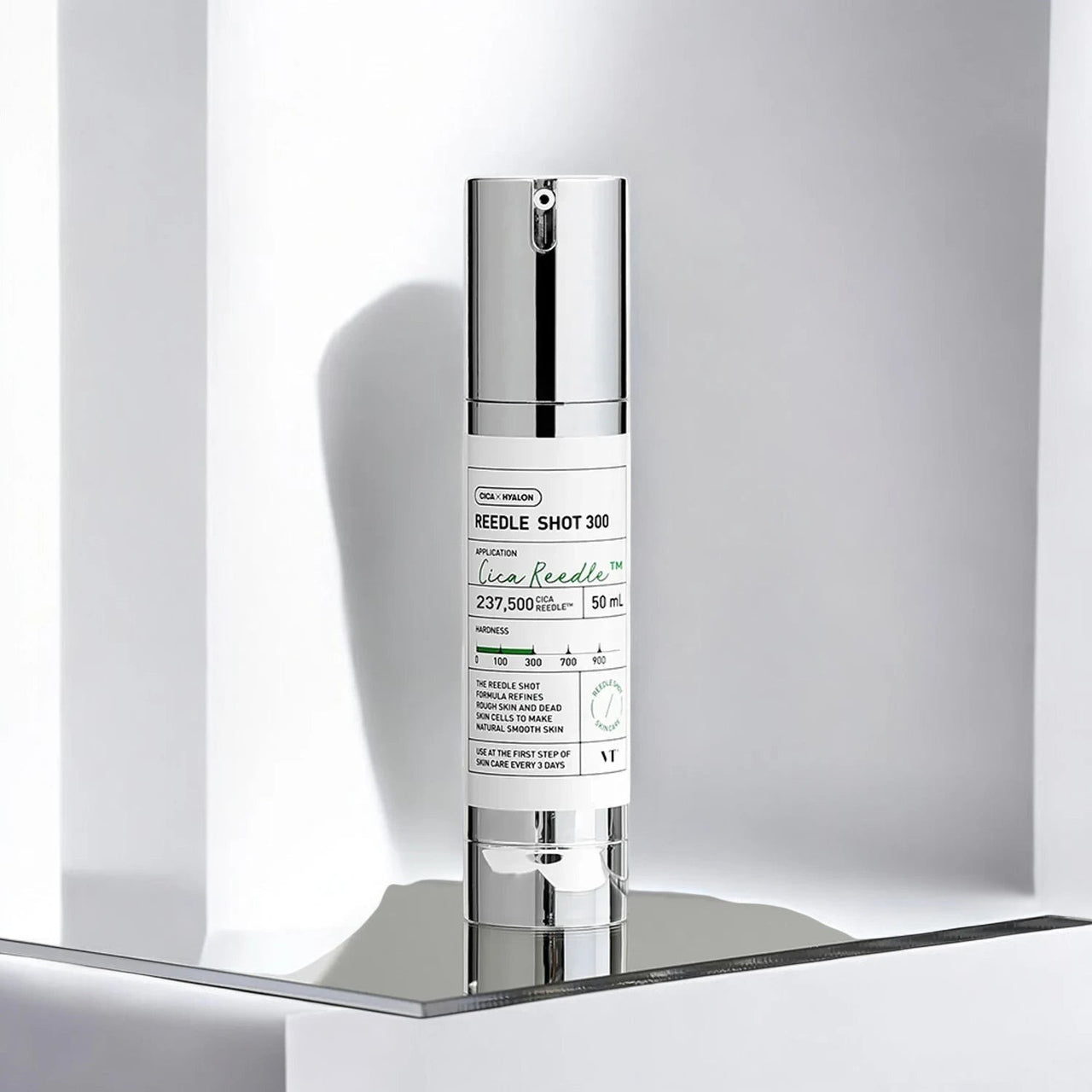 Skin TOGO VT Cosmetics Reedle Shot 300 essence bottle with silver cap on a modern white reflective display shelf