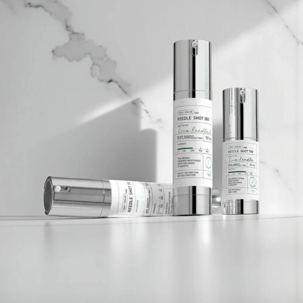 Skin TOGO VT Cosmetics Reedle Shot 700 and other variants in white pump bottles on a marble surface.